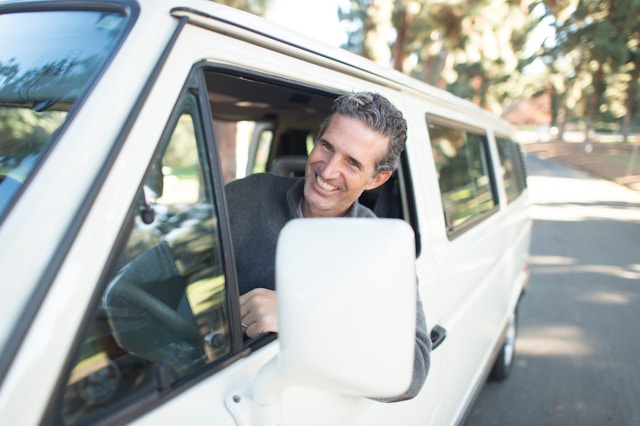 "A smiling person confidently comparing auto insurance quotes on a tablet, with diverse car models in the background