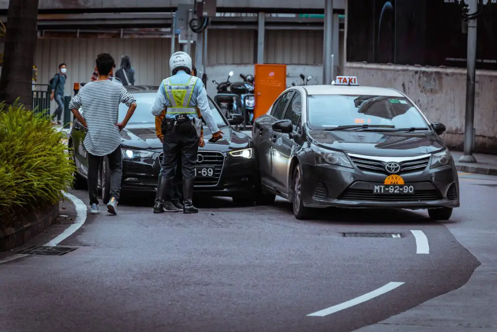 distressed driver looking at damaged car after accident