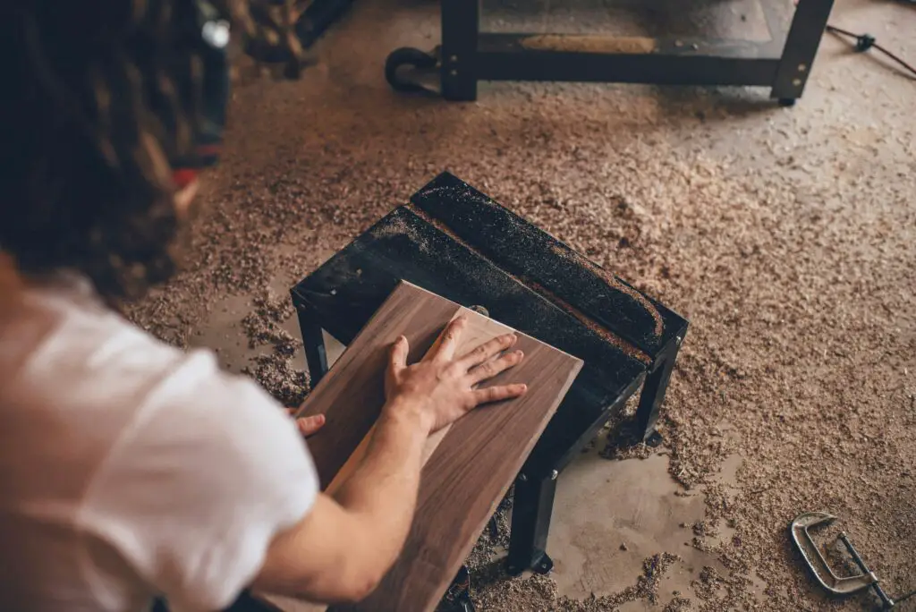 carpenter measuring wood with tools in workshop