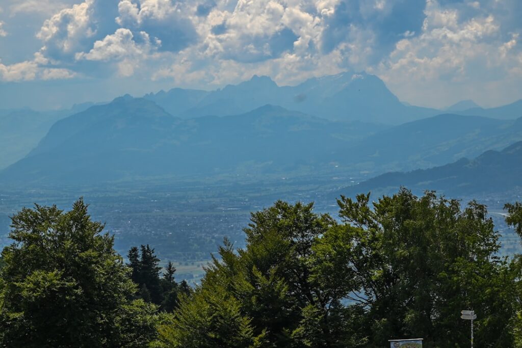 1. Malerische Uferpromenade am Bodensee mit Blick auf den See und die Alpen im Hintergrund.