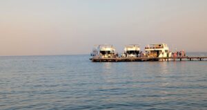 1. Eine Person meditiert ruhig am Strand bei Sonnenuntergang.